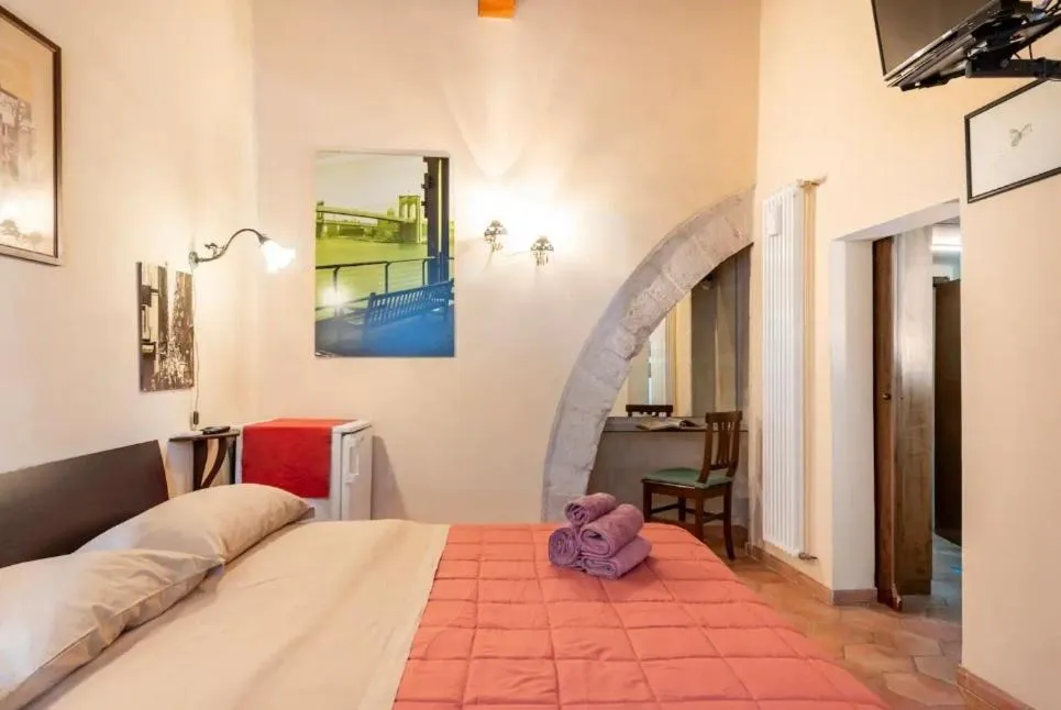 Il letto della camera e l’arco in pietra di Camera Corte